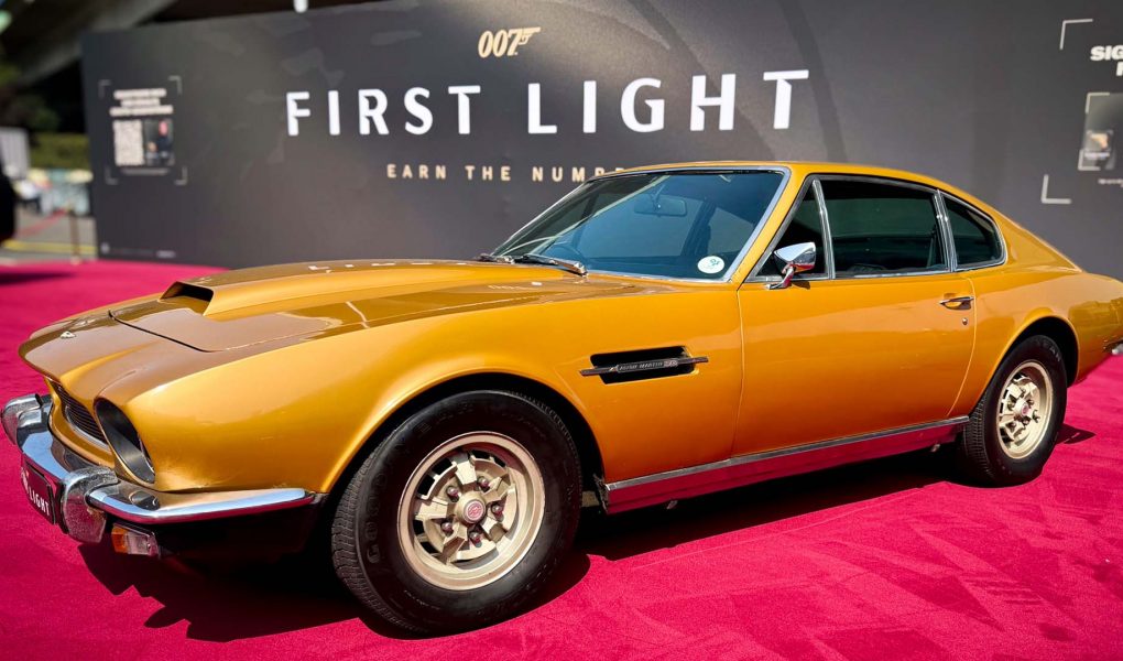 Yellow Aston Martin DBS from 007: First Light on display at IO Interactive’s Gamescom 2025 booth, showcased as part of the Bond vehicle lineup.