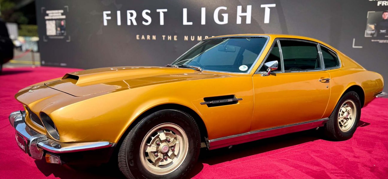 Yellow Aston Martin DBS from 007: First Light on display at IO Interactive’s Gamescom 2025 booth, showcased as part of the Bond vehicle lineup.