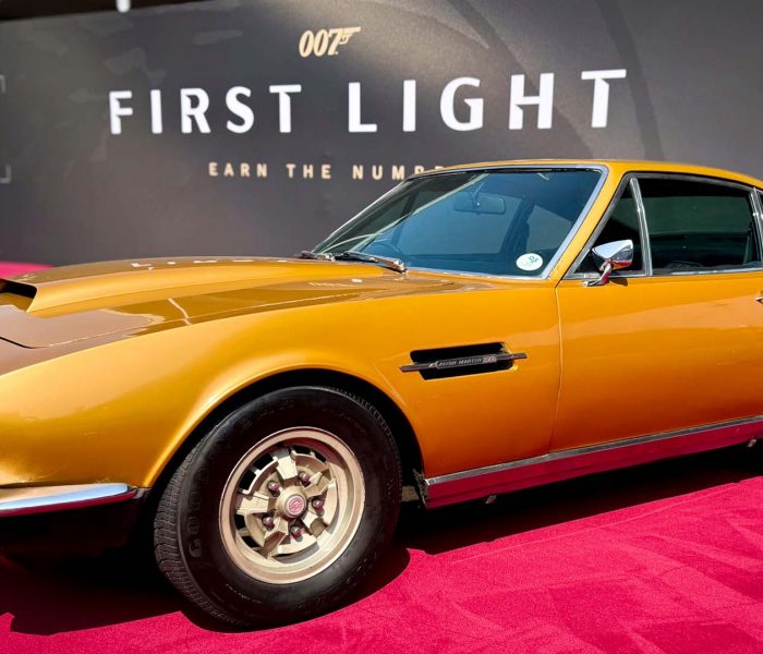 Yellow Aston Martin DBS from 007: First Light on display at IO Interactive’s Gamescom 2025 booth, showcased as part of the Bond vehicle lineup.