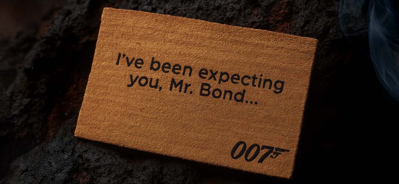 Official James Bond 007 doormat with the quote “I’ve been expecting you, Mr. Bond…” placed on a rugged lava stone ground.