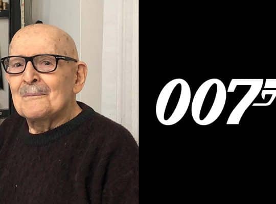 Photo of designer Joe Caroff next to his 007 Logo for James Bond