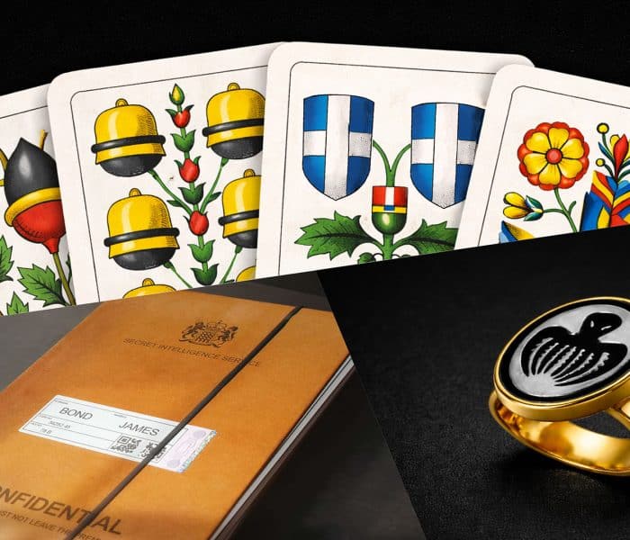 Confidential MI6 file for James Bond, Swiss-German Jass playing cards, and a gold Spectre ring featuring the iconic octopus symbol in 007 First Light